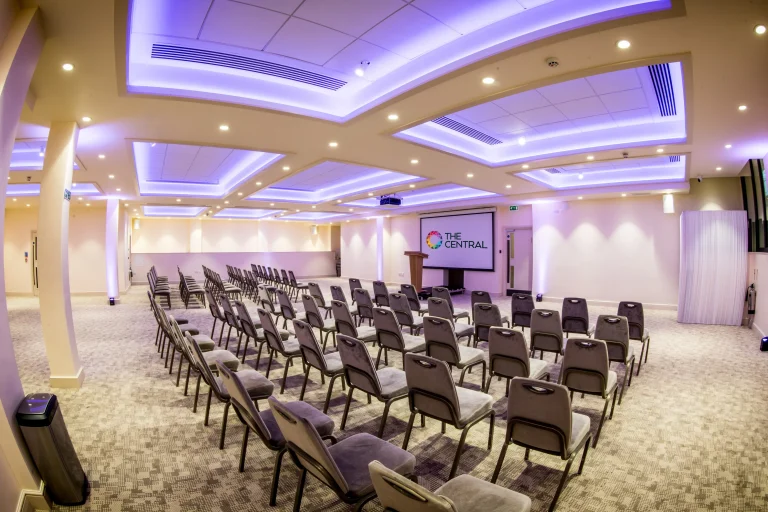 Wolfson Hall space set up in a theatre style layout with a large screen at the front with The Central's logo on